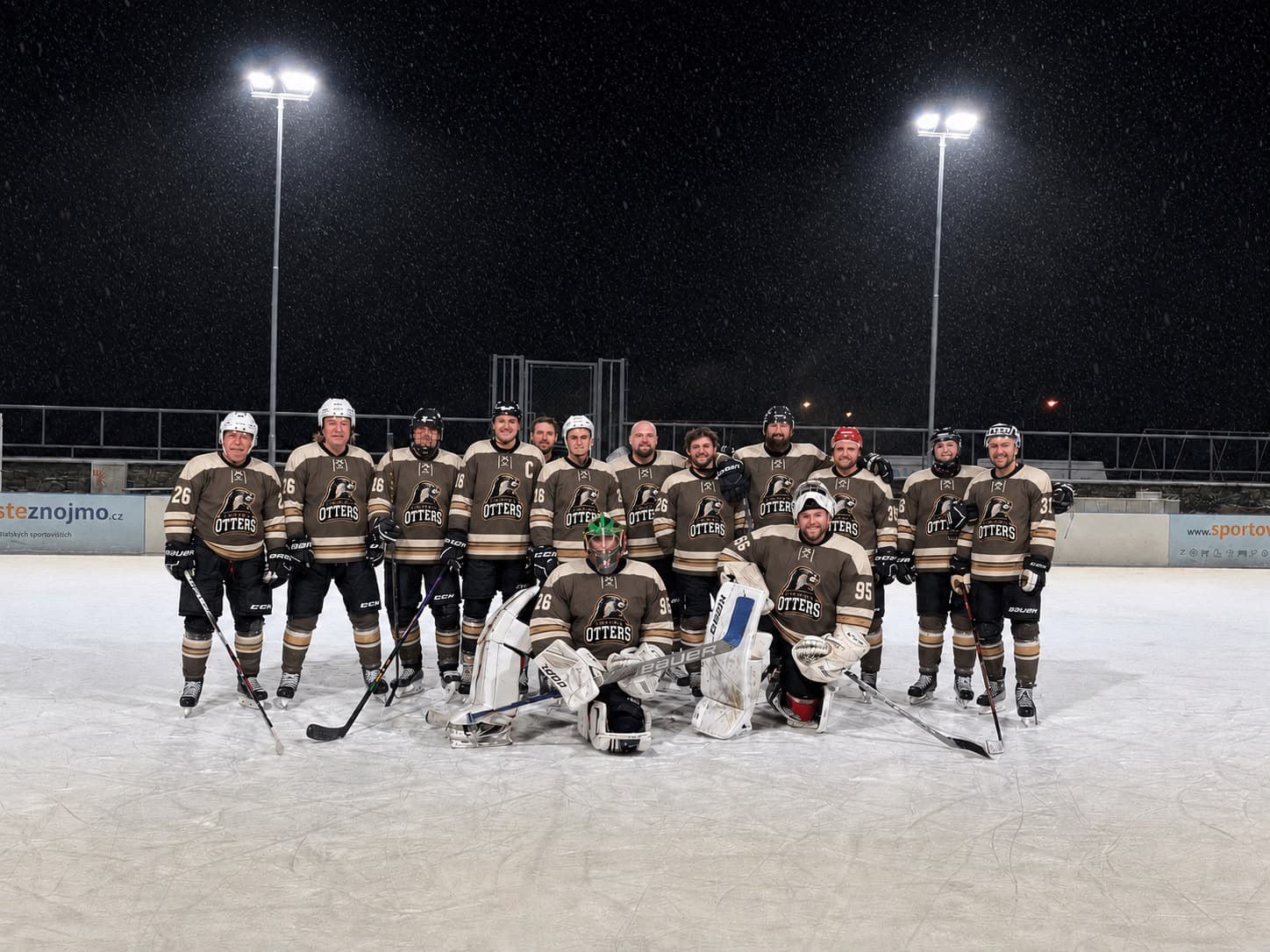 Znojmo Otters v hnědých dresech, sněží na venkovním kluzišti